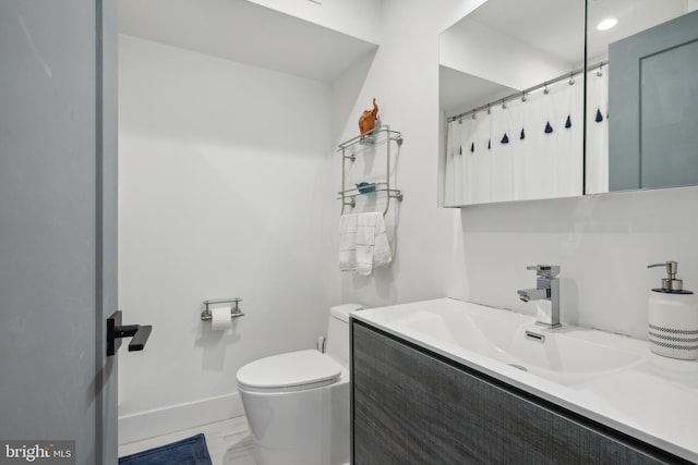 bathroom featuring vanity, a shower with shower curtain, and toilet