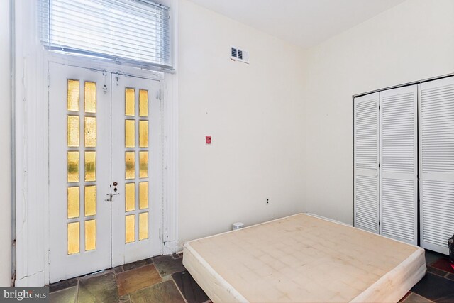 unfurnished bedroom featuring french doors and a closet