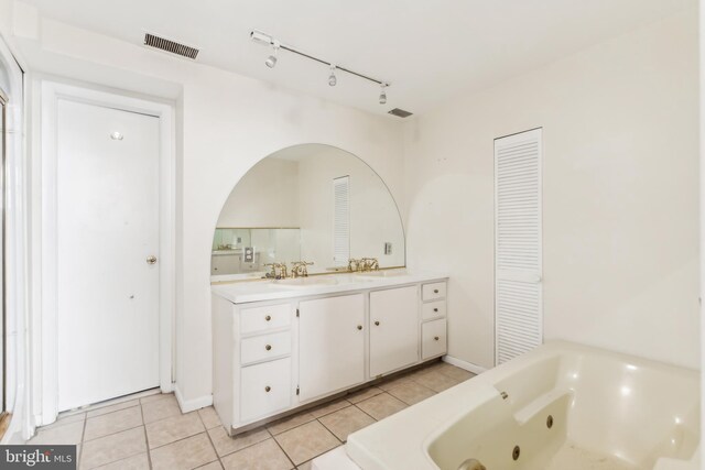 bathroom with tile patterned floors, vanity, and a washtub