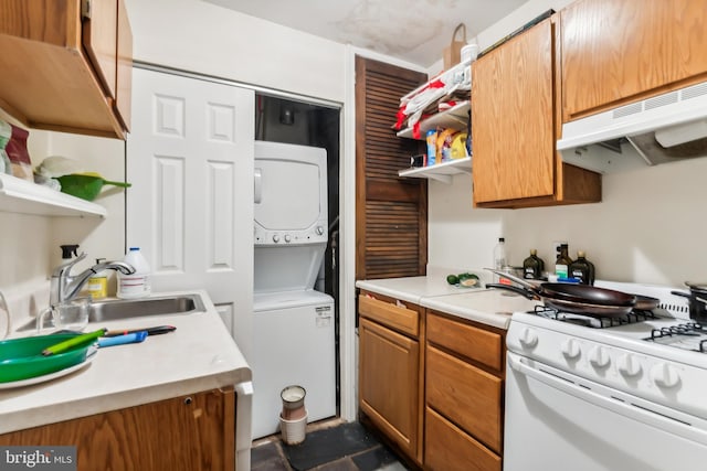 kitchen with stacked washer / drying machine, sink, and gas range gas stove