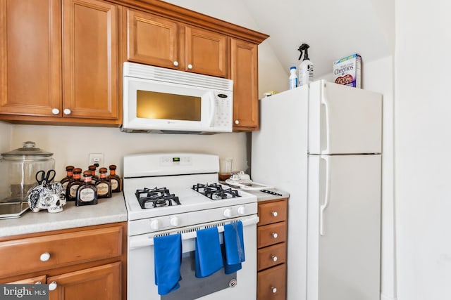 kitchen with lofted ceiling and white appliances