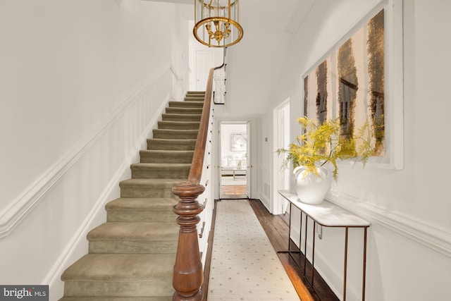 stairs featuring an inviting chandelier