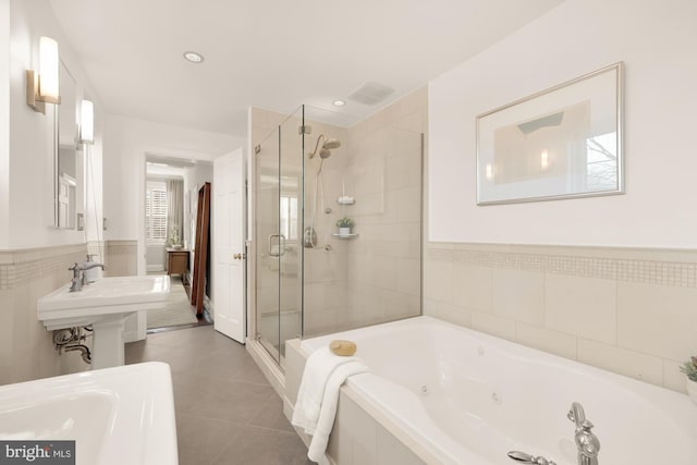 bathroom with tile patterned flooring, plus walk in shower, and tile walls