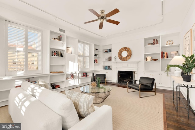 living room featuring ceiling fan, hardwood / wood-style floors, and built in features