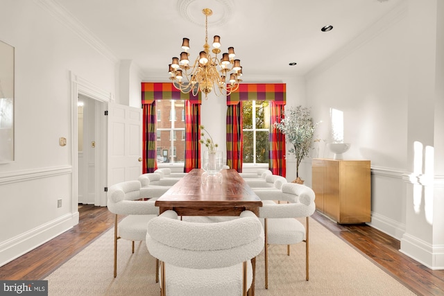 dining space with ornamental molding, hardwood / wood-style floors, and an inviting chandelier