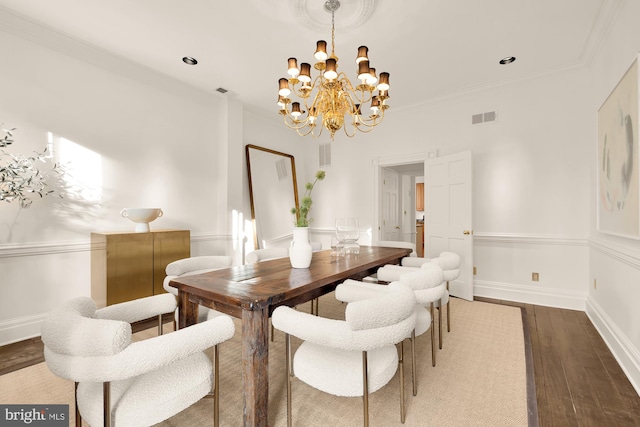 dining space featuring ornamental molding, dark wood-type flooring, and an inviting chandelier