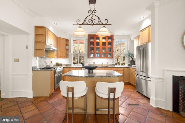 kitchen with decorative light fixtures, a breakfast bar area, premium appliances, a center island, and crown molding