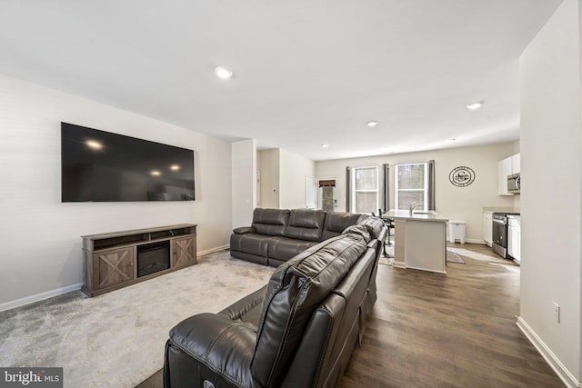 living room featuring sink, dark hardwood / wood-style floors, and a fireplace