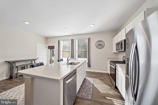 kitchen featuring dark hardwood / wood-style floors, sink, white cabinetry, a kitchen island with sink, and stainless steel appliances