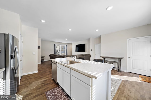 kitchen featuring an island with sink, stainless steel appliances, dark wood-type flooring, white cabinets, and sink