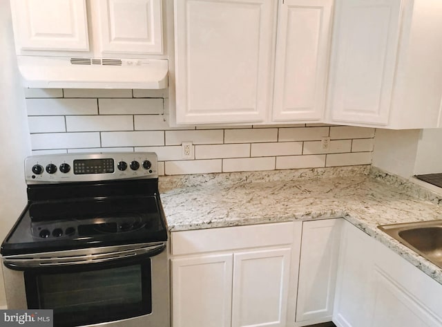 kitchen with stainless steel electric range oven, decorative backsplash, white cabinetry, and light stone counters