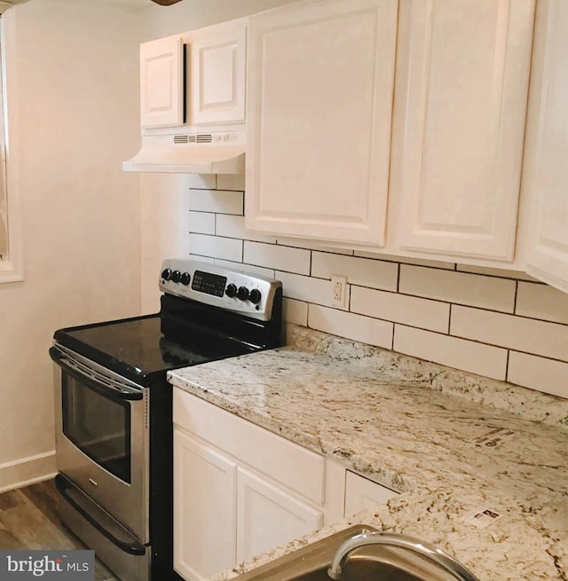 kitchen featuring tasteful backsplash, wood-type flooring, stainless steel electric range, white cabinets, and light stone counters