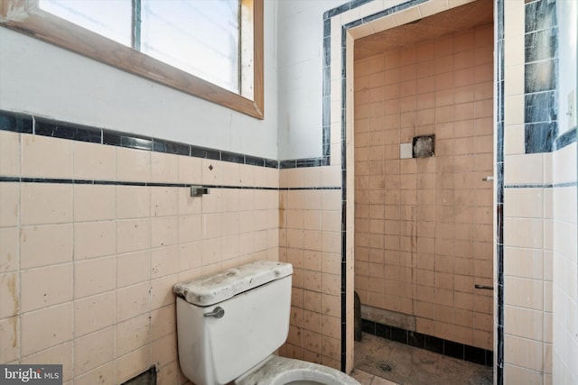 bathroom with toilet and tile walls