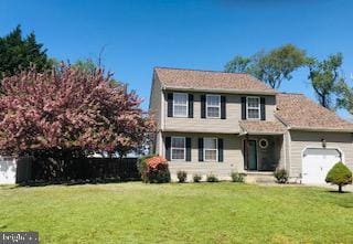 view of front of property featuring a garage and a front yard