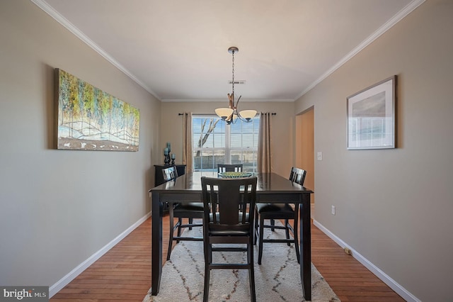 dining space with a notable chandelier, hardwood / wood-style flooring, and ornamental molding