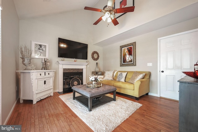 living room featuring hardwood / wood-style flooring, vaulted ceiling, and ceiling fan