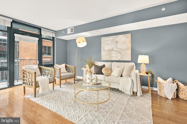 living room with expansive windows and hardwood / wood-style floors