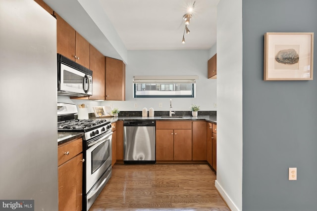 kitchen with appliances with stainless steel finishes, dark hardwood / wood-style flooring, and sink