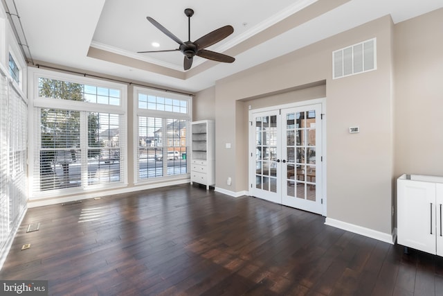 interior space with dark wood-type flooring, french doors, ornamental molding, ceiling fan, and a tray ceiling