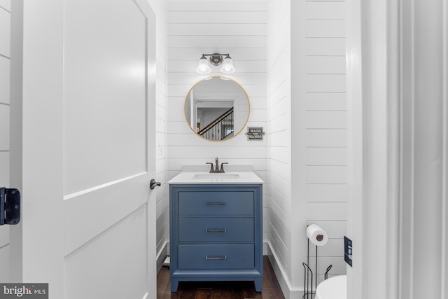 bathroom featuring vanity and wooden walls