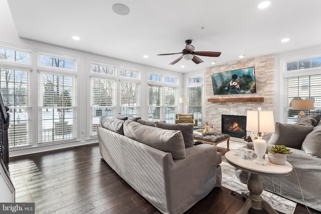 living room featuring a fireplace, dark wood-type flooring, and ceiling fan