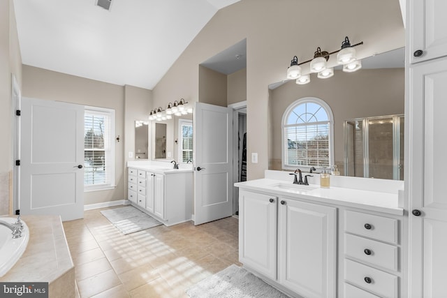 bathroom featuring vanity, vaulted ceiling, separate shower and tub, and tile patterned flooring