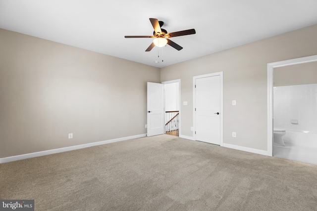 unfurnished bedroom featuring ceiling fan, ensuite bathroom, and carpet flooring