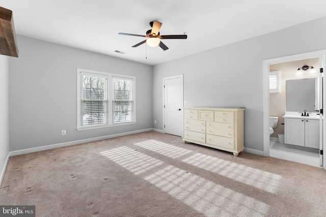 unfurnished bedroom with ceiling fan, sink, ensuite bathroom, and light carpet