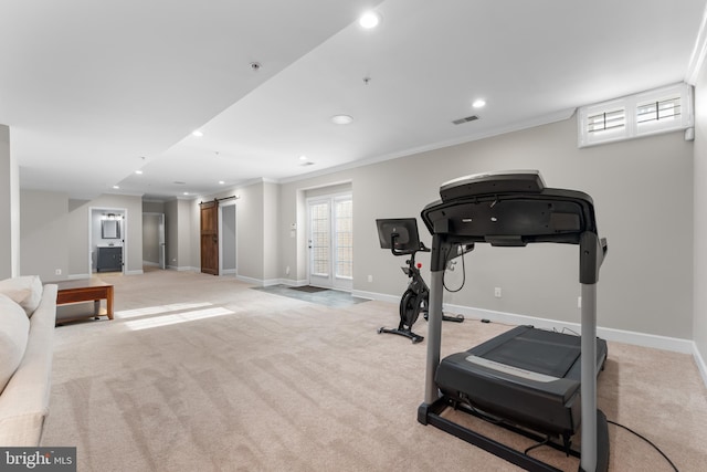 workout area with a barn door, crown molding, and light colored carpet