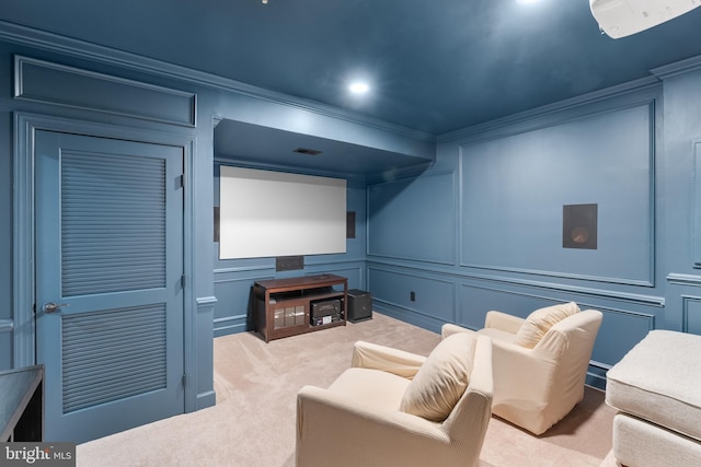 home theater room with light colored carpet and crown molding