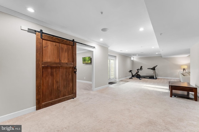 workout area with light colored carpet, crown molding, and a barn door