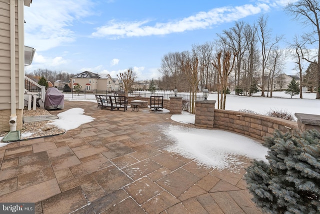 snow covered patio with a grill