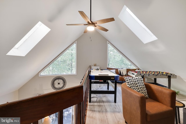 office with ceiling fan, light hardwood / wood-style floors, and lofted ceiling with skylight