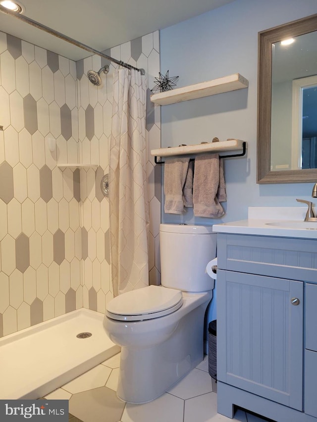 bathroom with tile patterned floors, toilet, curtained shower, and vanity