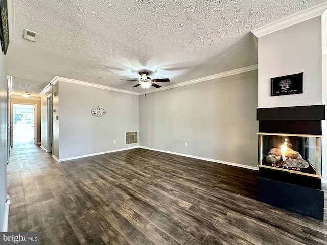 unfurnished living room with a multi sided fireplace, ornamental molding, dark wood-type flooring, and ceiling fan