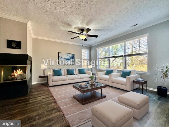 living room with hardwood / wood-style flooring, crown molding, a textured ceiling, and ceiling fan