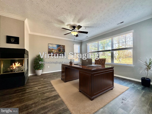 home office featuring crown molding, ceiling fan, dark hardwood / wood-style floors, a multi sided fireplace, and a textured ceiling