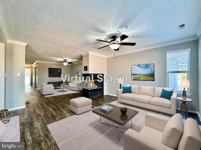 living room featuring crown molding, ceiling fan, wood-type flooring, and a textured ceiling