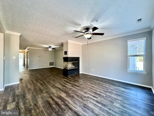 unfurnished living room featuring a multi sided fireplace, dark hardwood / wood-style flooring, ceiling fan, crown molding, and a textured ceiling