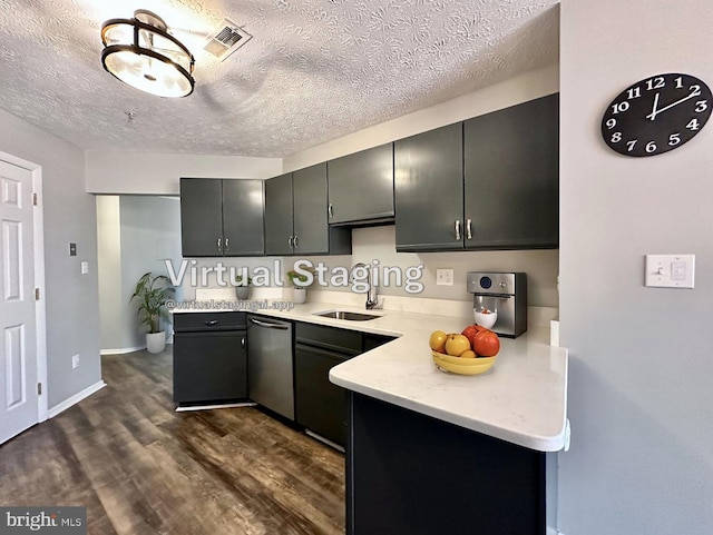 kitchen featuring dark wood-type flooring, sink, gray cabinetry, a textured ceiling, and dishwasher