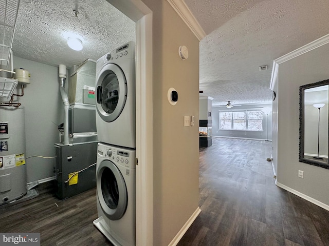 laundry area with stacked washing maching and dryer, water heater, crown molding, dark wood-type flooring, and a textured ceiling