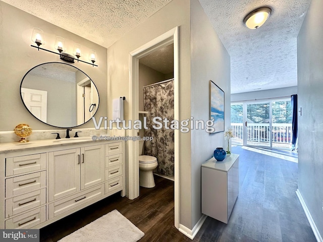 bathroom featuring vanity, a textured ceiling, wood-type flooring, and toilet