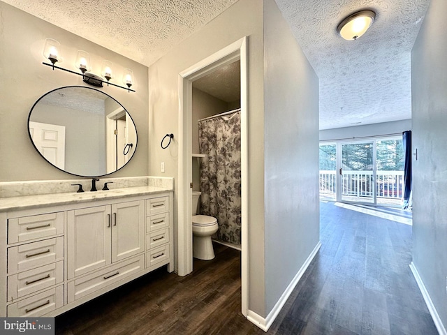 bathroom with vanity, hardwood / wood-style floors, a textured ceiling, and toilet