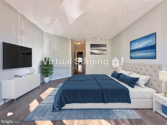 bedroom with a textured ceiling and dark hardwood / wood-style flooring