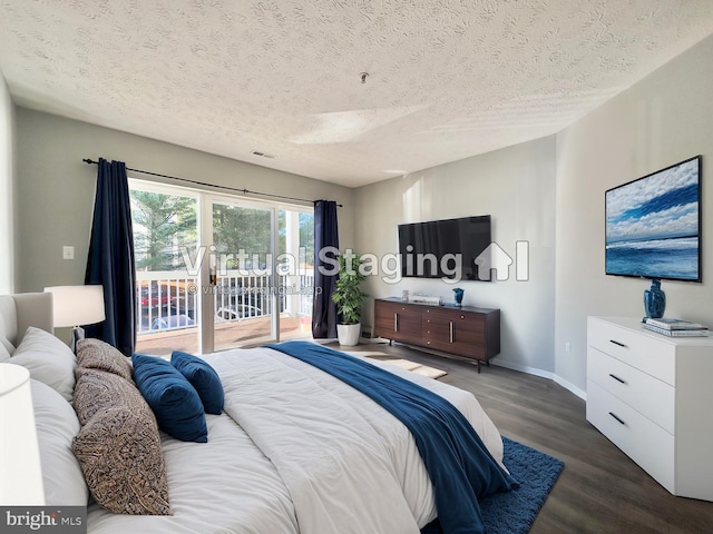 bedroom featuring dark hardwood / wood-style floors, access to exterior, and a textured ceiling