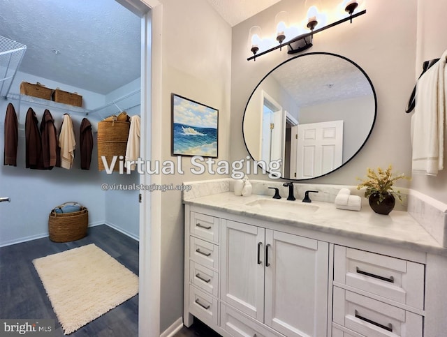 bathroom with vanity, wood-type flooring, and a textured ceiling