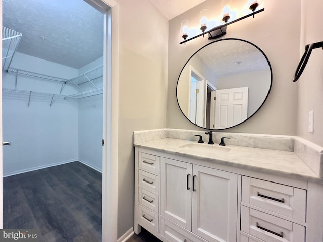 bathroom featuring hardwood / wood-style flooring, vanity, and a textured ceiling