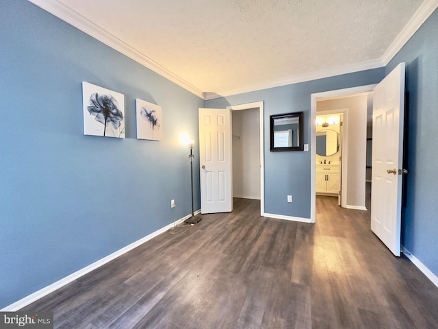 unfurnished bedroom with ornamental molding, dark hardwood / wood-style floors, and a textured ceiling