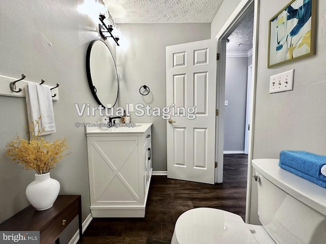 bathroom featuring vanity, wood-type flooring, a textured ceiling, and toilet