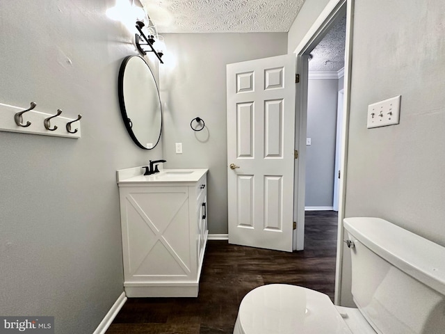 bathroom featuring hardwood / wood-style flooring, vanity, a textured ceiling, and toilet